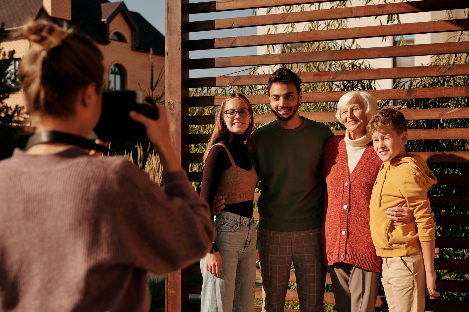 A cheerful family posing outdoors for a photograph on a sunny day, capturing generations together in harmony.